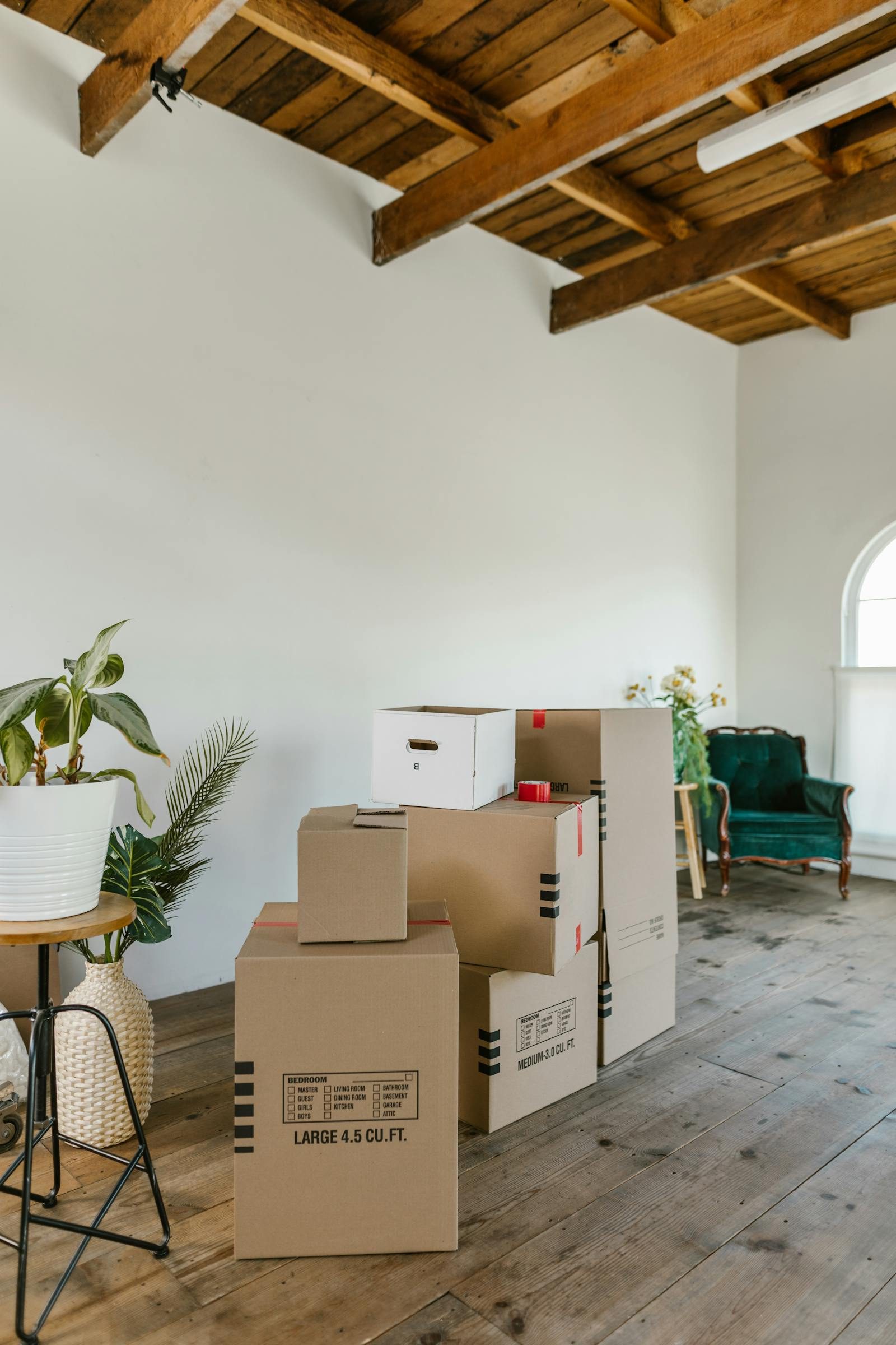 Stack of labelled moving boxes (Bedroom, Living Room, Kitchen) in an empty Sydney room ready for storage